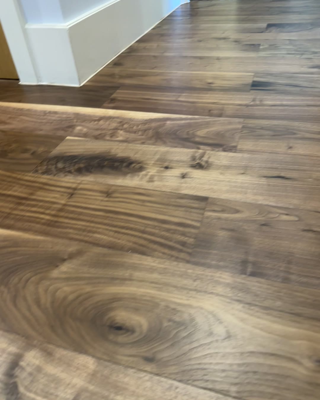 Restored engineered walnut hallway with rich grain and clean white skirting